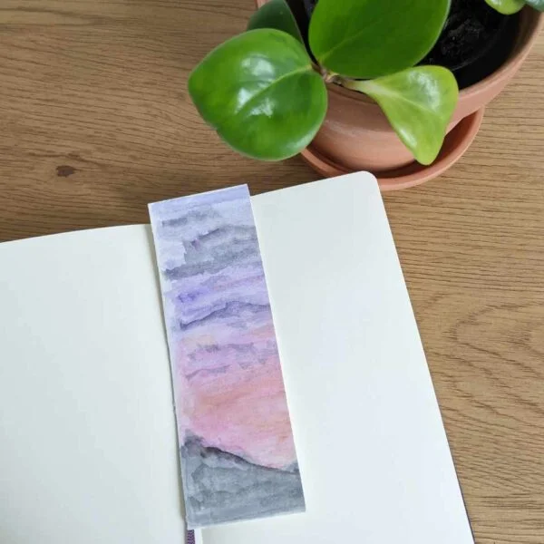 Moody Sunset bookmark with book and plant on desk