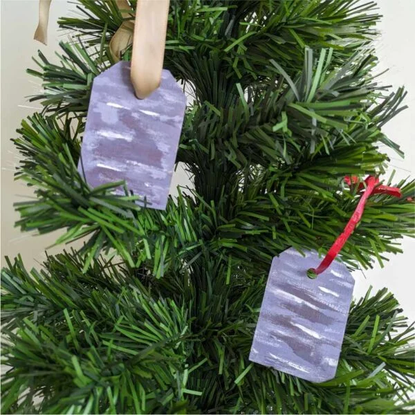 gift tags with abstract purple design as ornaments on tree