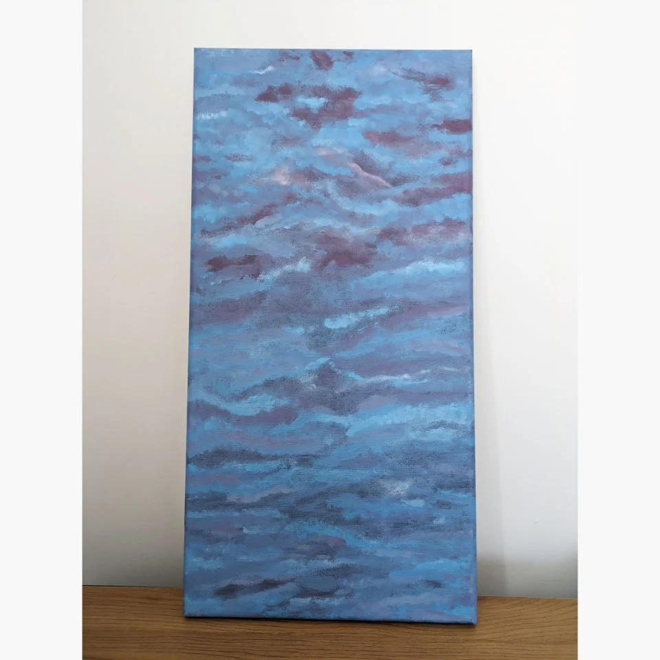 table with large canvas painting of dark cloudy sky