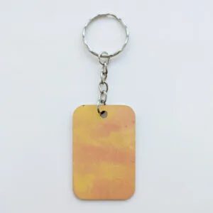 wood keychain with yellow and orange abstract design